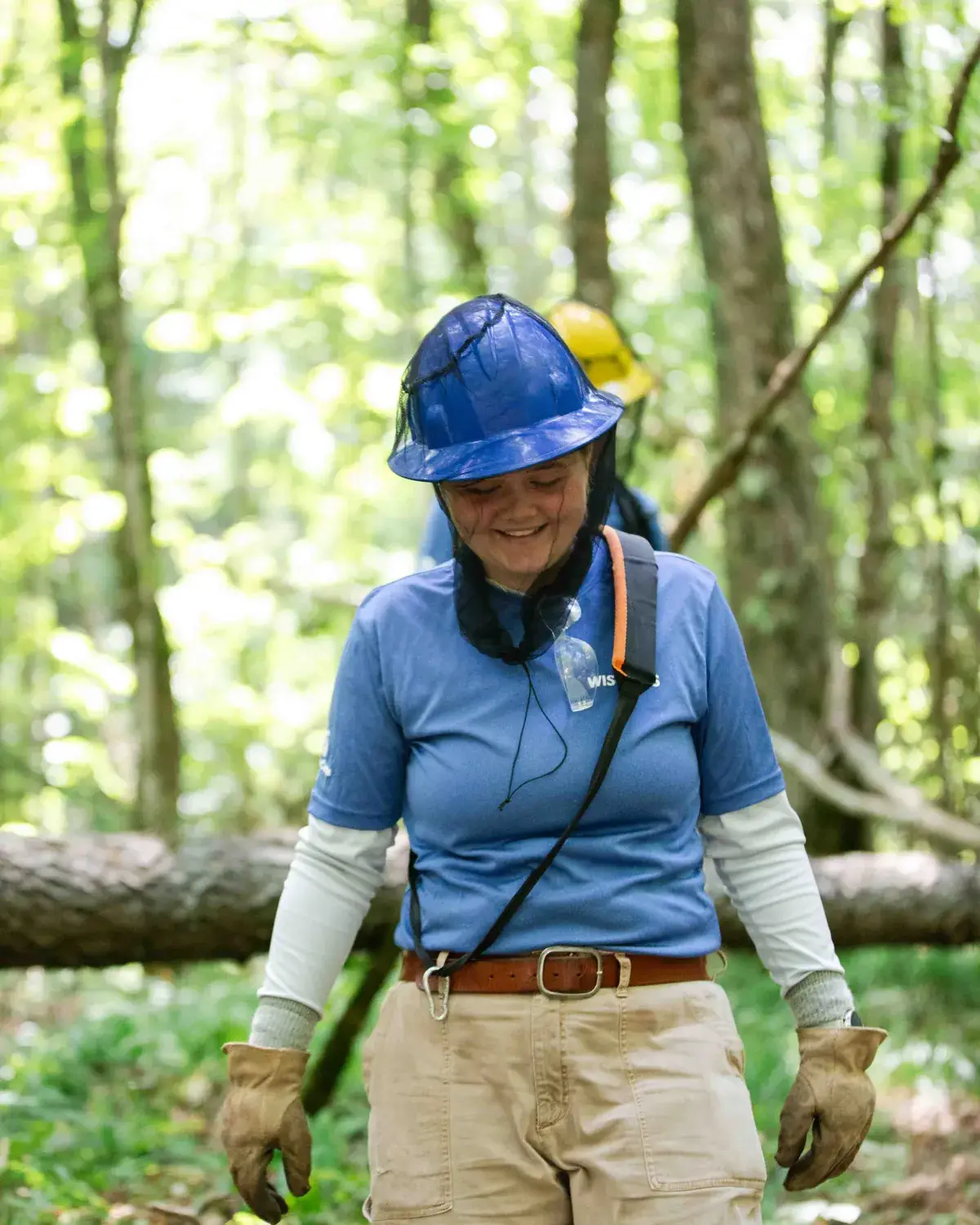 A WisCorps crew member in a hard hat on a forest project